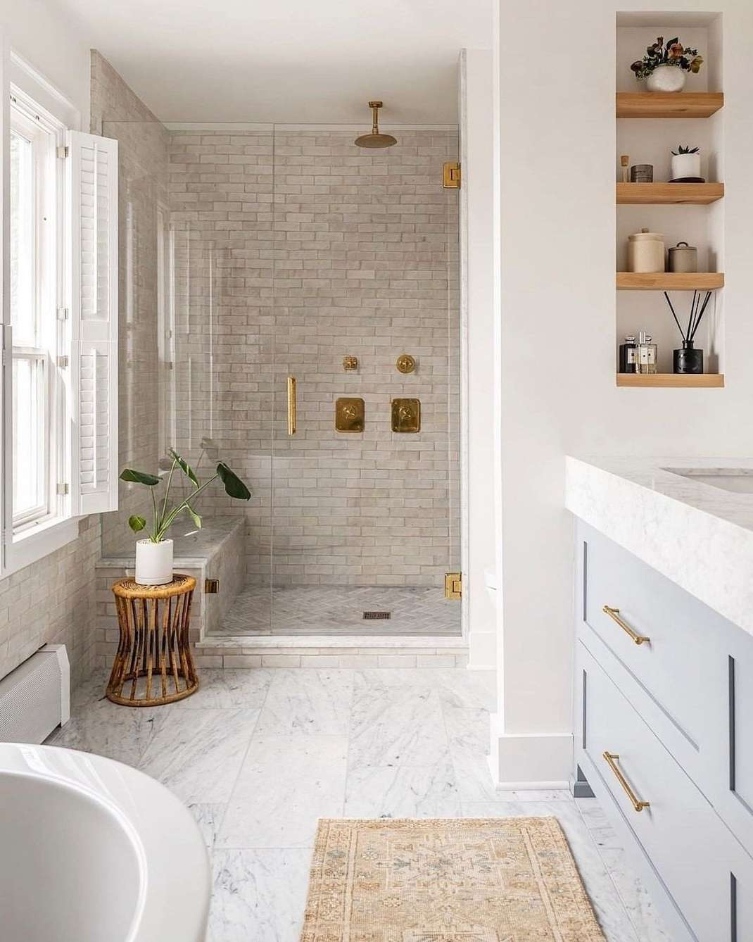 Minimalistisches Badezimmer mit Naturholz, goldenen Armaturen, beigen Fliesen und Marmorfußboden