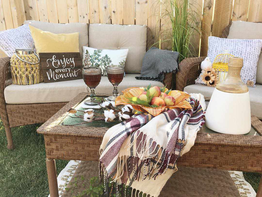 sofás ao ar livre com mesa e cesta de maçãs