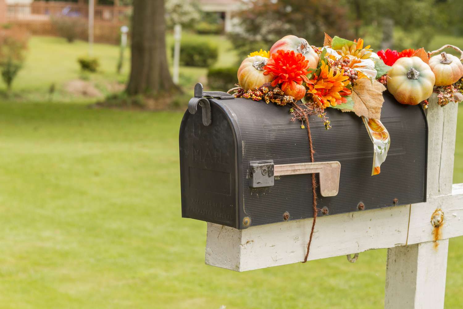 schwarzer Briefkasten mit Herbstdekoration oben drauf