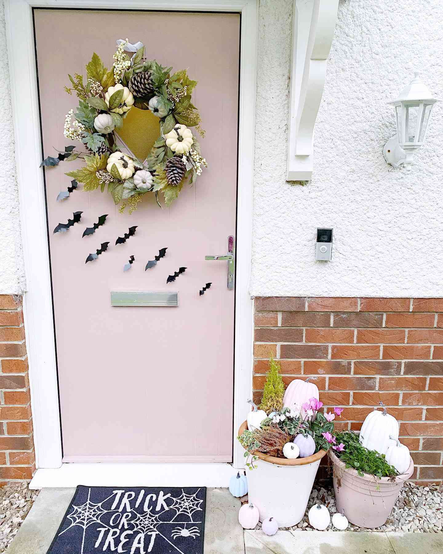 porta da frente decorada para o outono com morcegos e coroa de flores