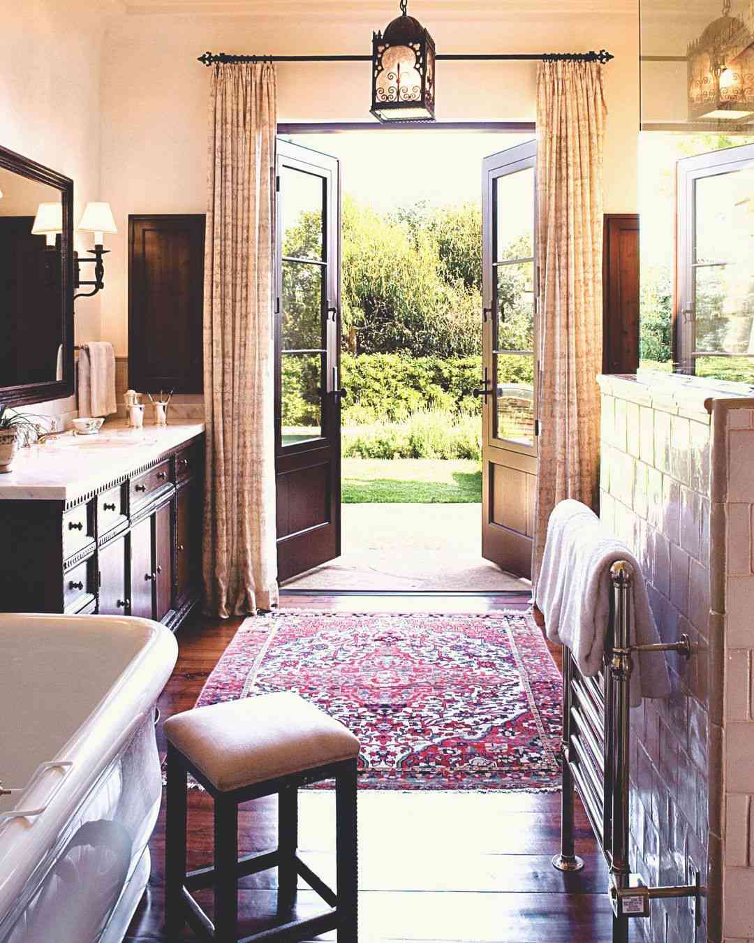 Badezimmer mit Zugang zum Garten, dunklem Holz und klassischen Details