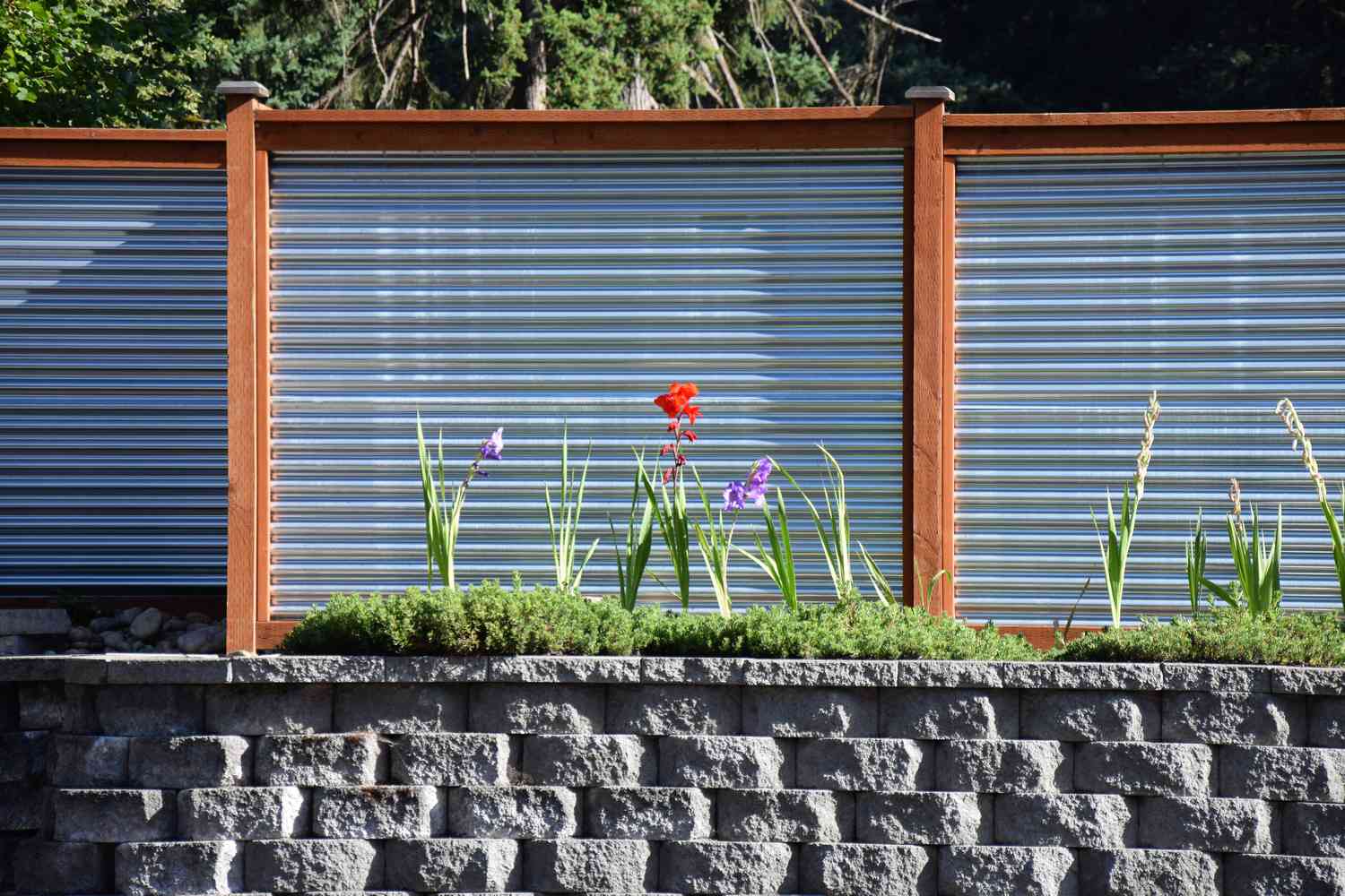 Une clôture faite de métal, de bois et de pavés