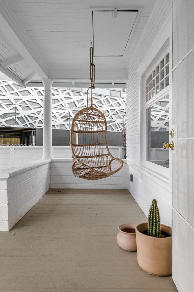 Hanging Wicker Chair In White Porch