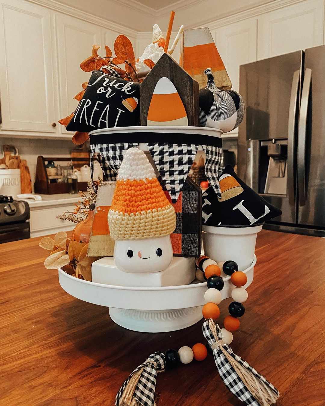 Fall decorations in a tiered stand on a kitchen island