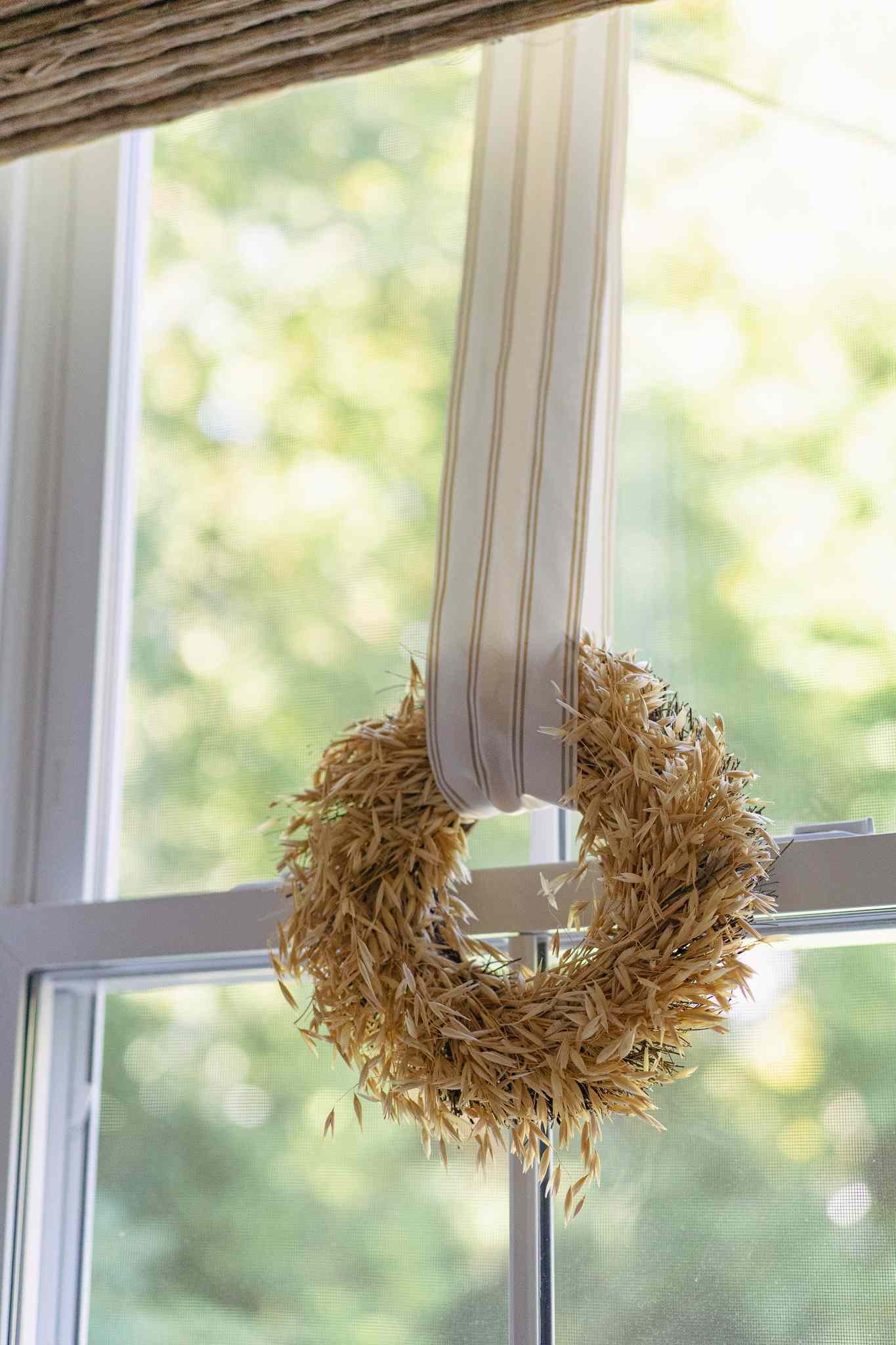 Corona de otoño colgada en una ventana de la cocina