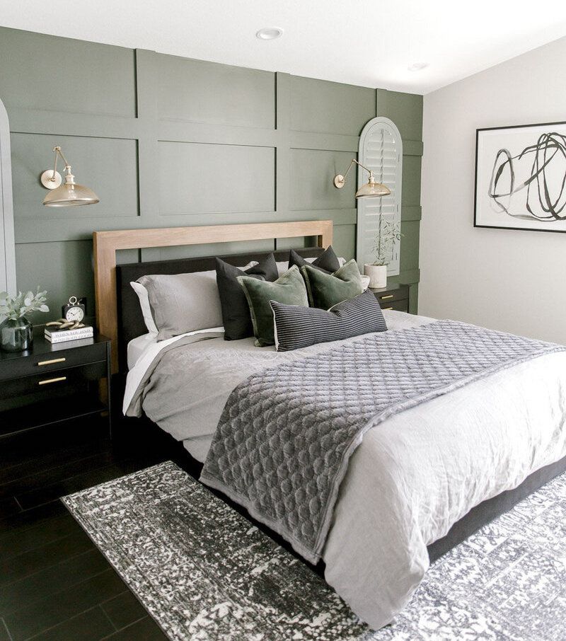 Chambre à coucher avec un mur d'accent vert olive avec des accents noirs.