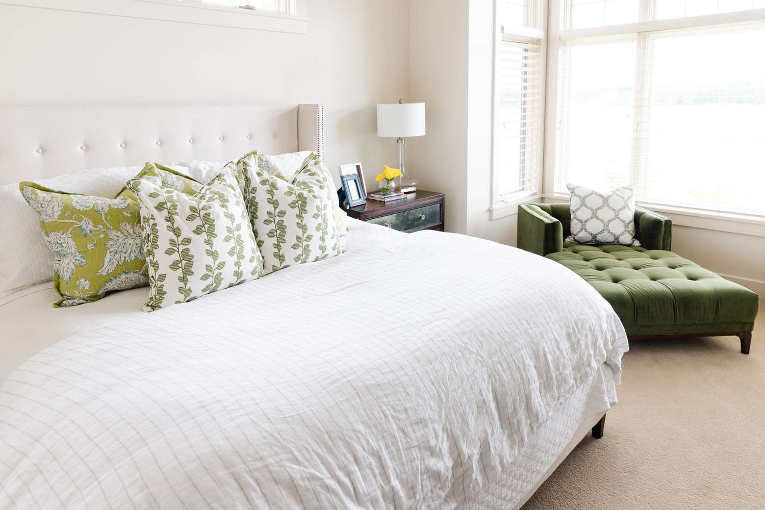 Helles weißes Schlafzimmer mit olivgrünen Farbtönen.