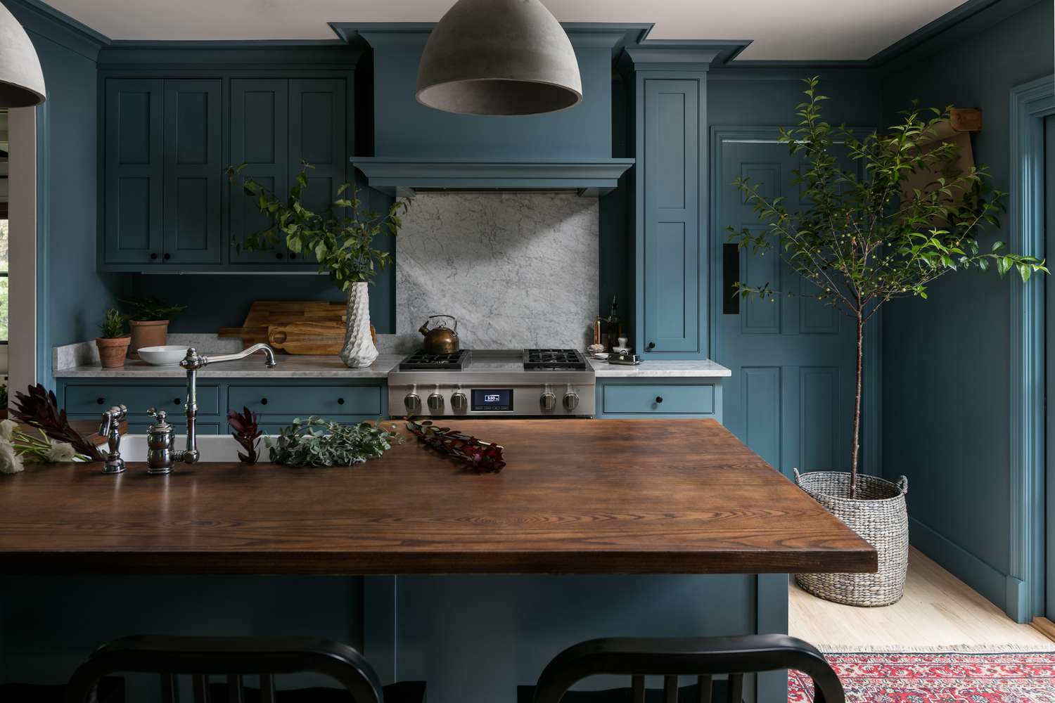 Blaue Küche mit Holzarbeitsplatte und Marmoraufkantung