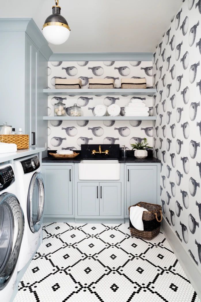 Papel de parede de pássaro caprichoso em uma lavanderia com armários azuis claros
