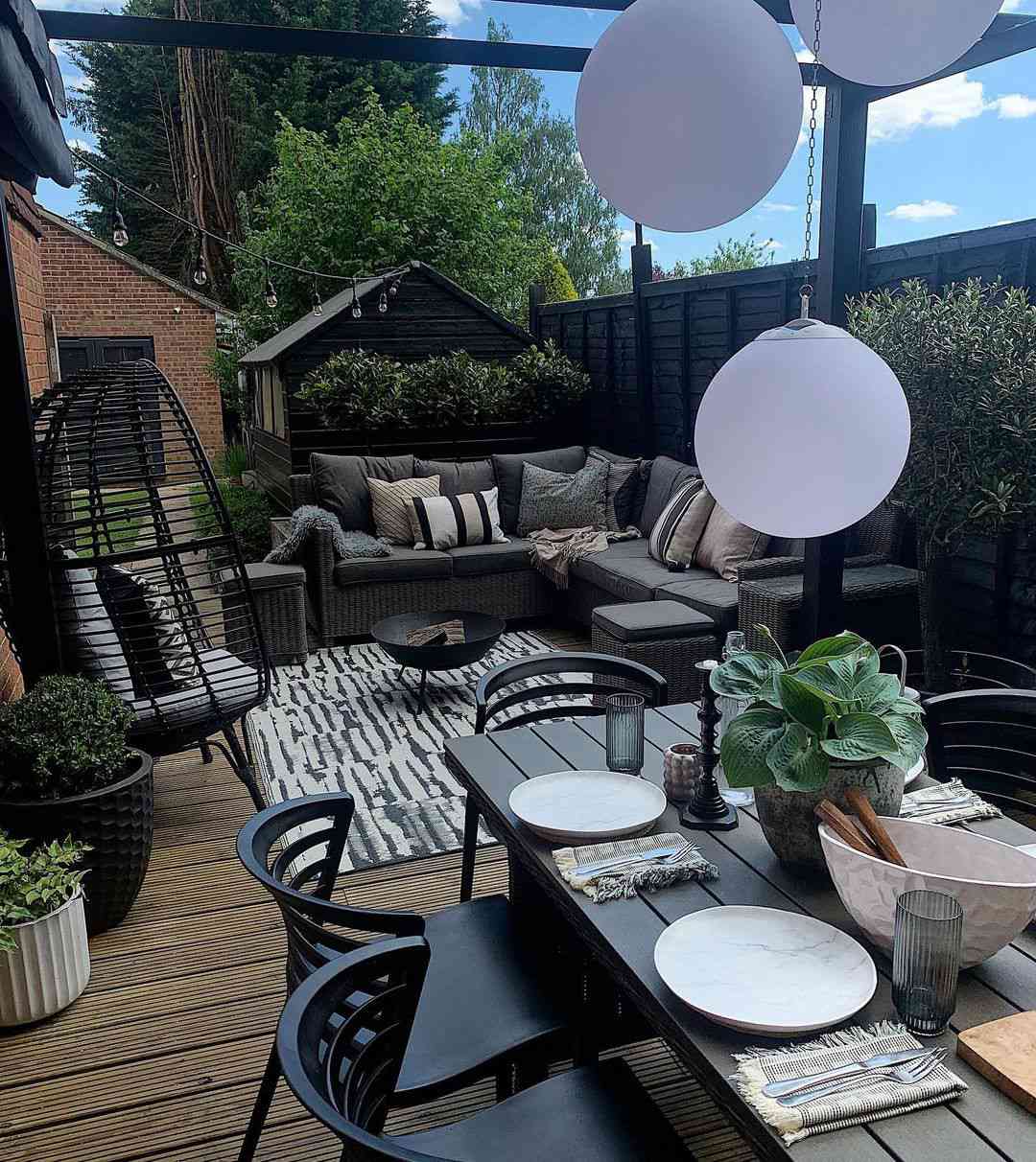 Uma área de estar e uma mesa de jantar em um jardim de canto