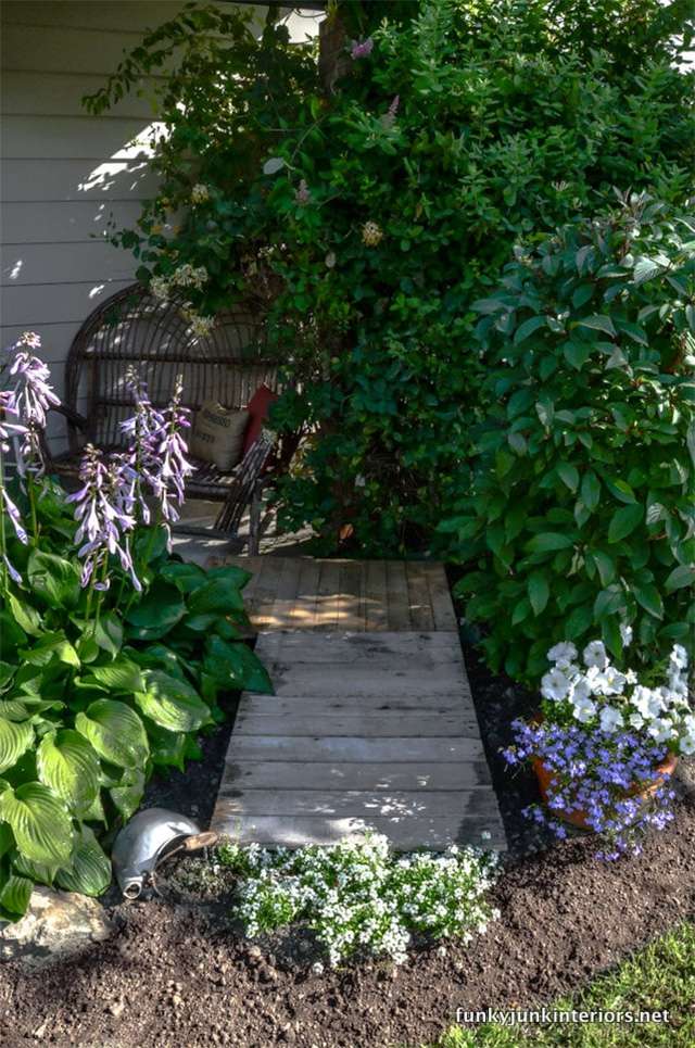 Un jardín esquinero con una pasarela de palets