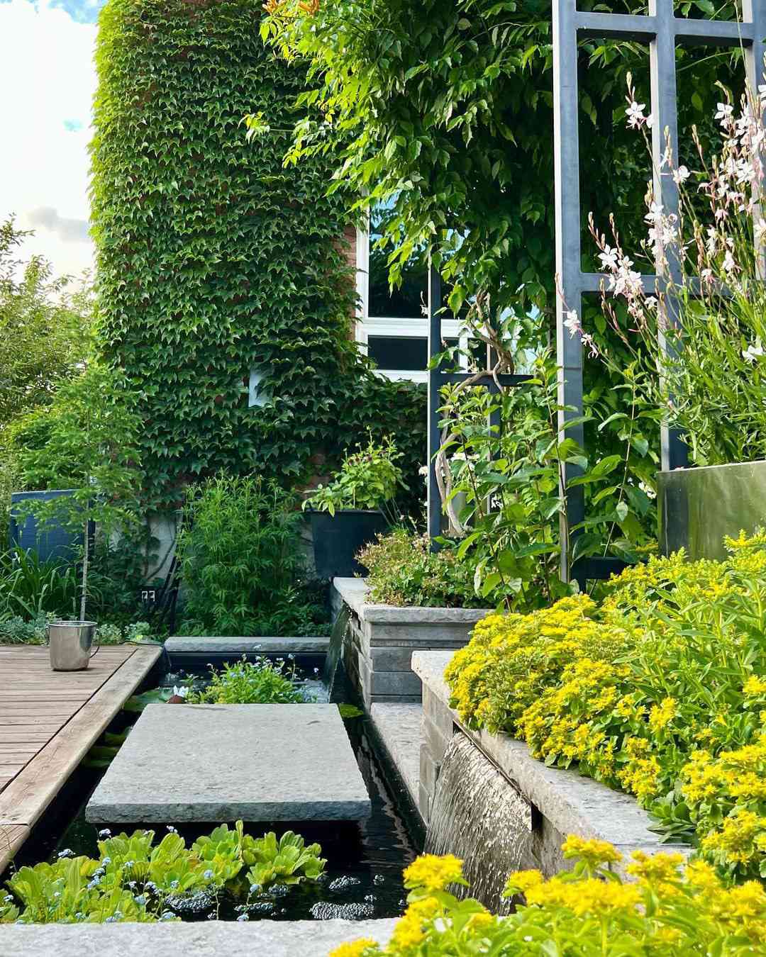 Una idea de jardín de esquina para añadir una fuente de agua