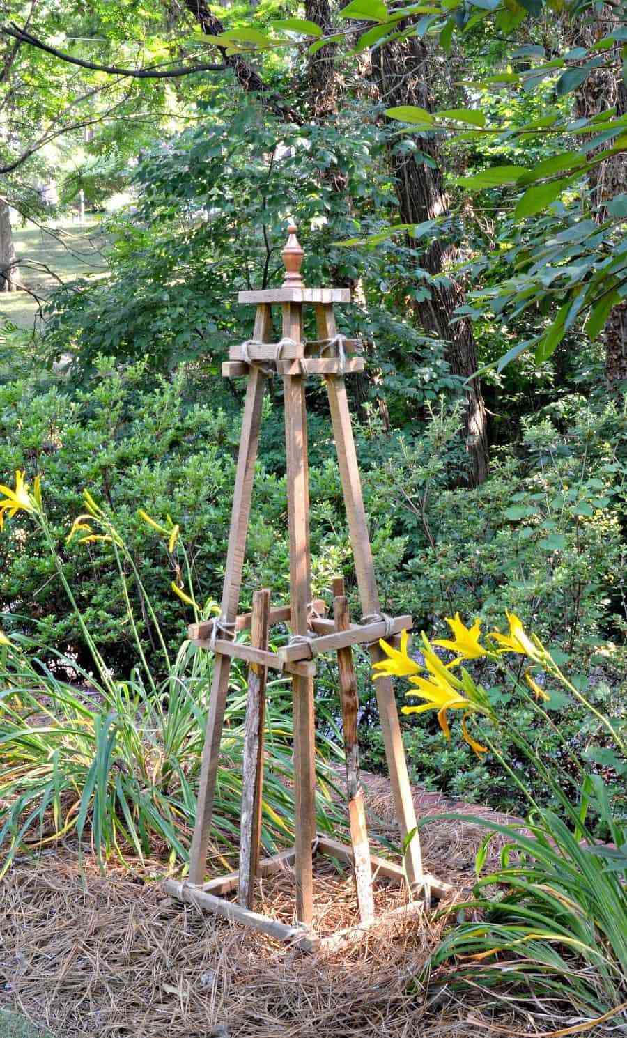 Um obelisco de madeira em um jardim de canto