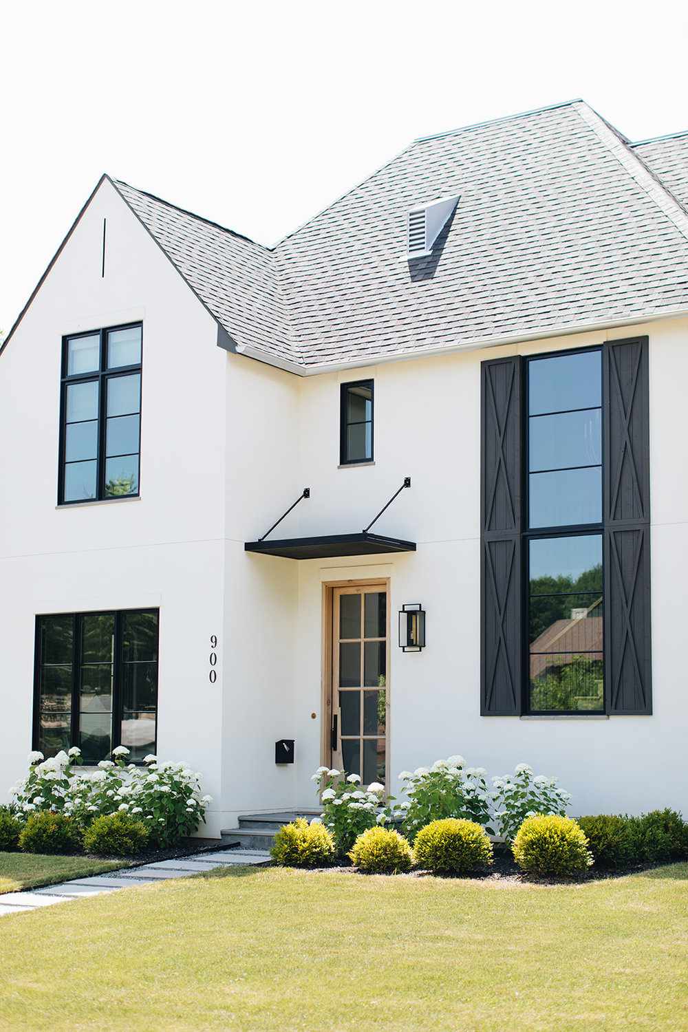 Übergroße schwarze Fensterläden an weißem Haus