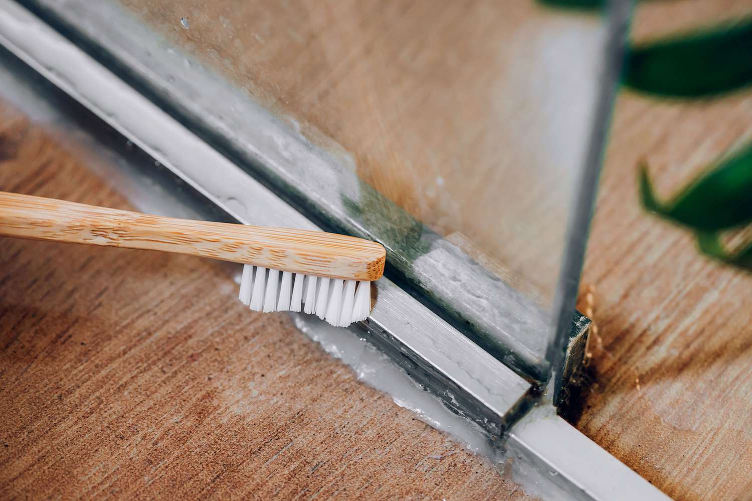 Old toothbrush scrubbing soap scum and grime covered with vinegar