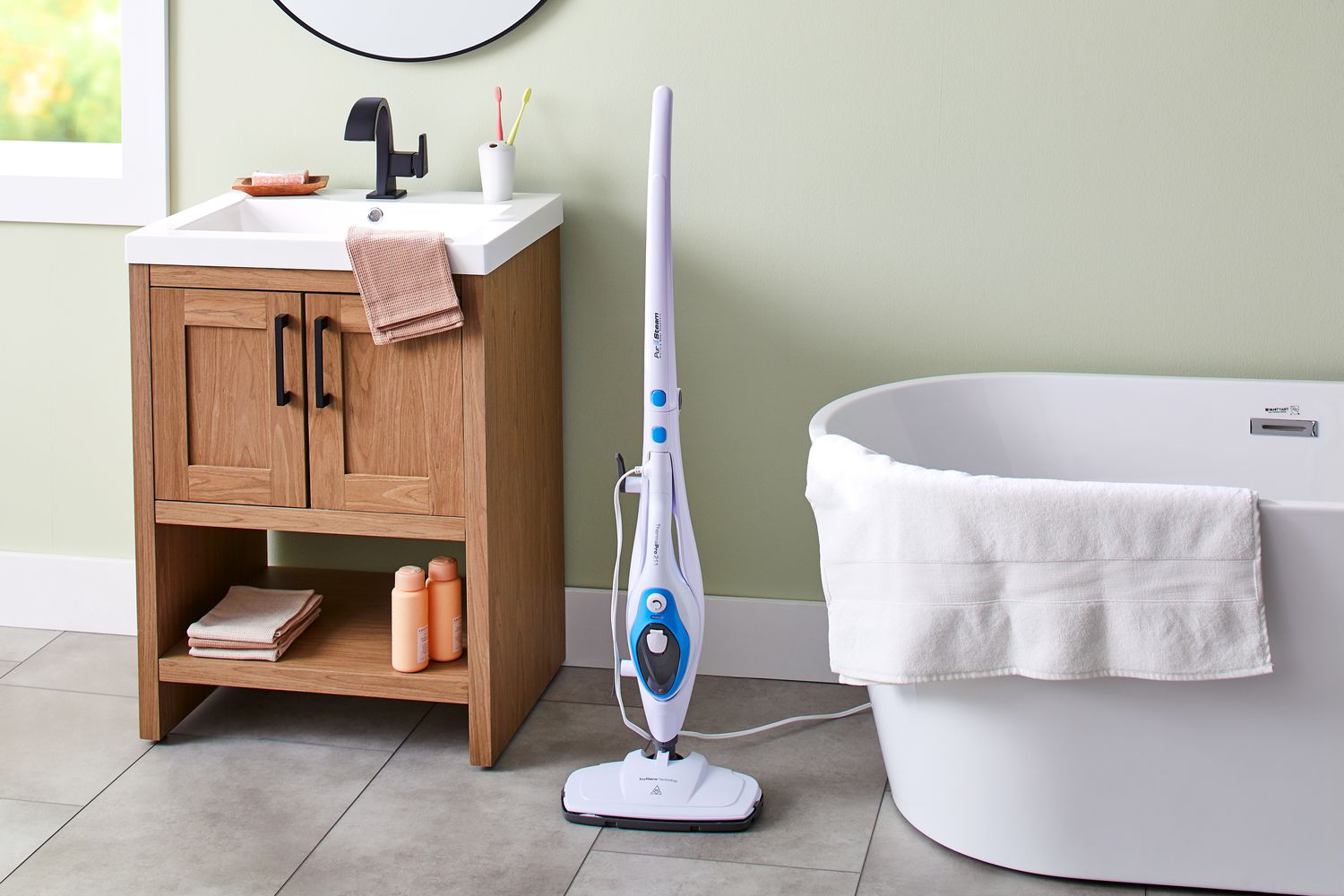 PurSteam 10-in-1 Steam Mop Cleaner affiché dans une salle de bain à côté d'un évier et d'une baignoire