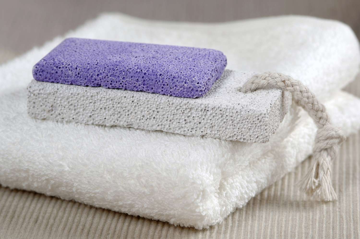 two pumice stones sit atop a towel.