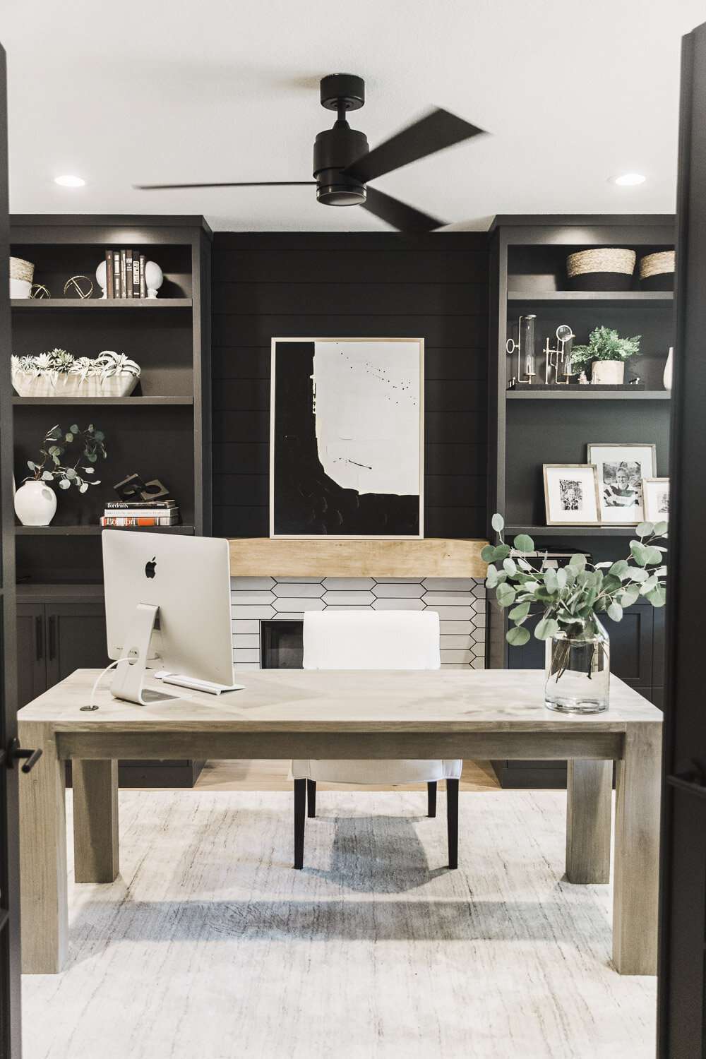 Home office with built-ins and a fireplace accent wall.