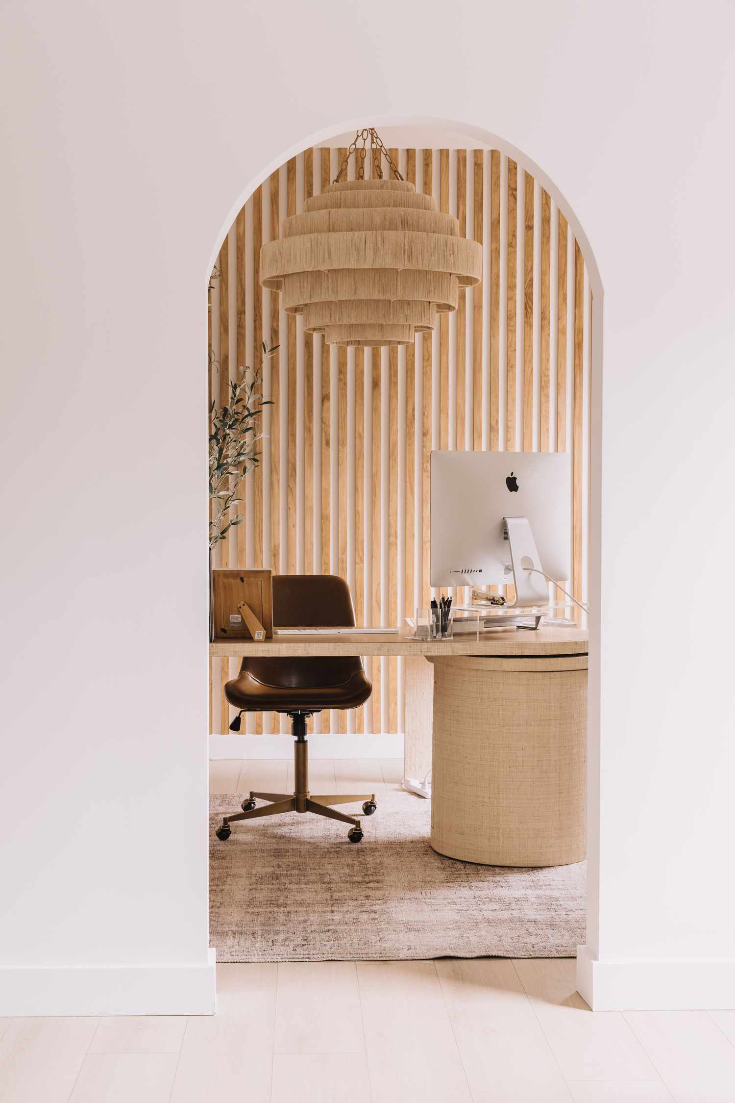 Office with wood paneling accent wall.