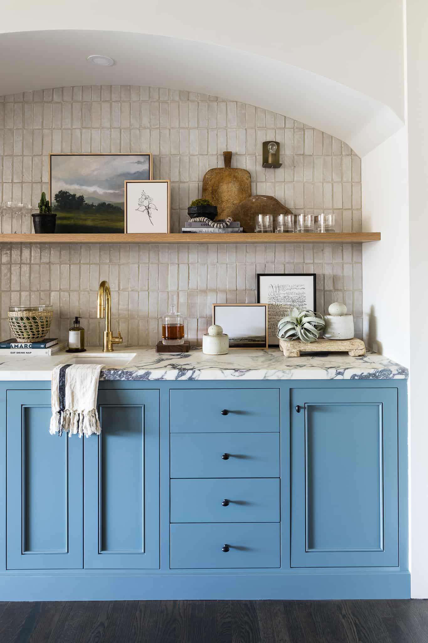 Cocina de granja con backsplash de azulejos grises y armarios azules 