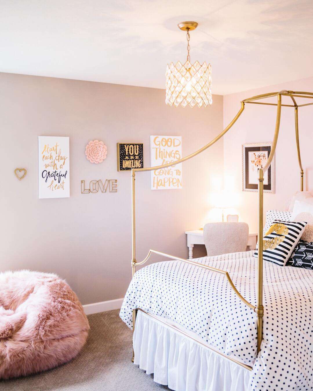 A girl's pink bedroom with gold frame bed