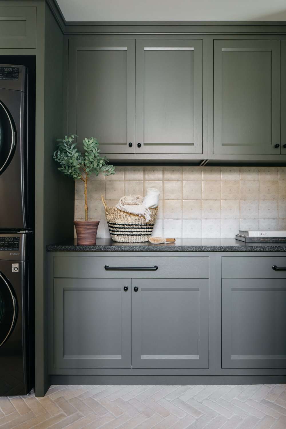 Dunkelgrün-graue Schränke in einer Waschküche mit beiger Aufkantung
