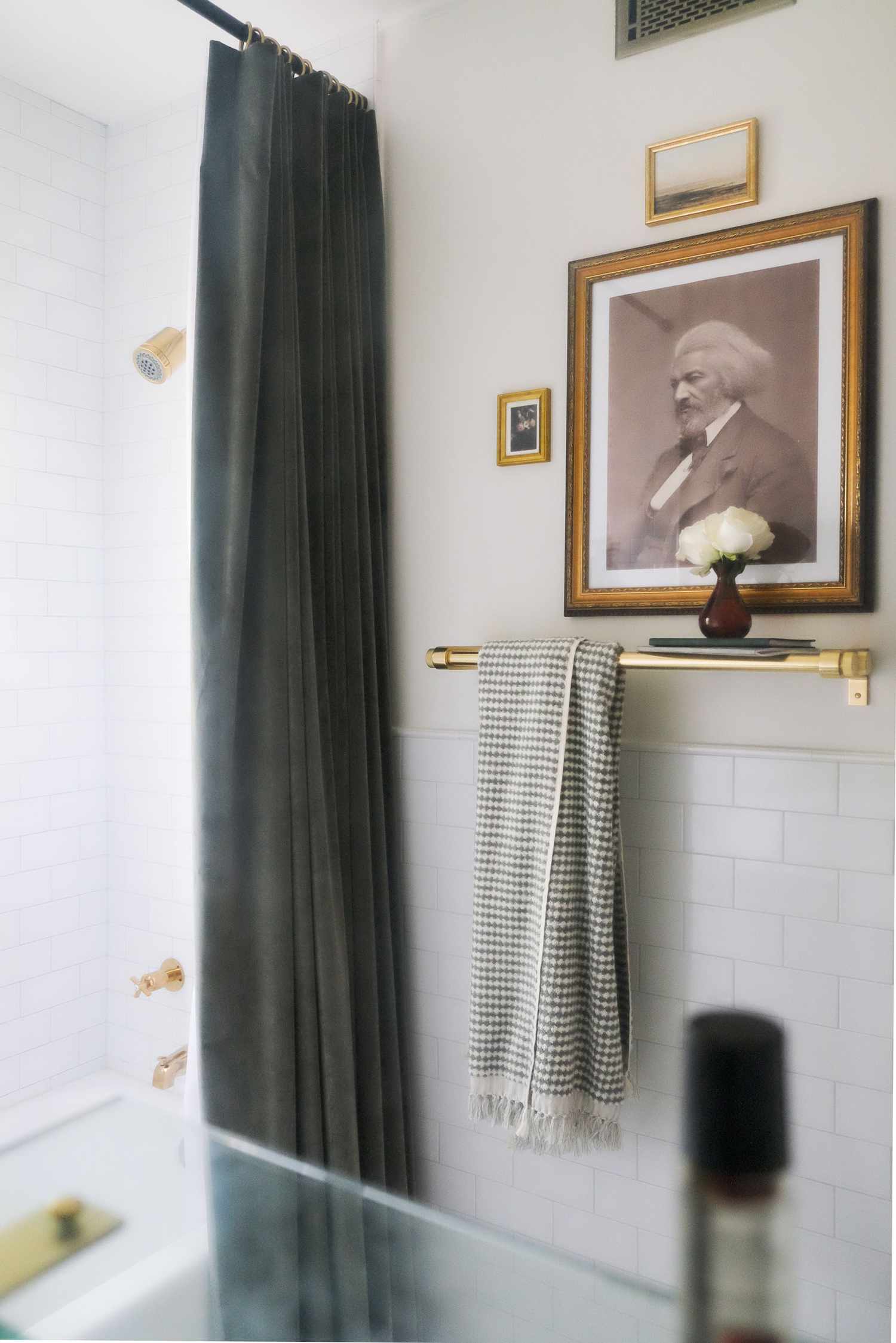 Ein Bild von Frederick Douglass in den Farben Schwarz, Grau, Weiß und Beige zelebriert das afroamerikanische Erbe in diesem kleineren Badezimmer