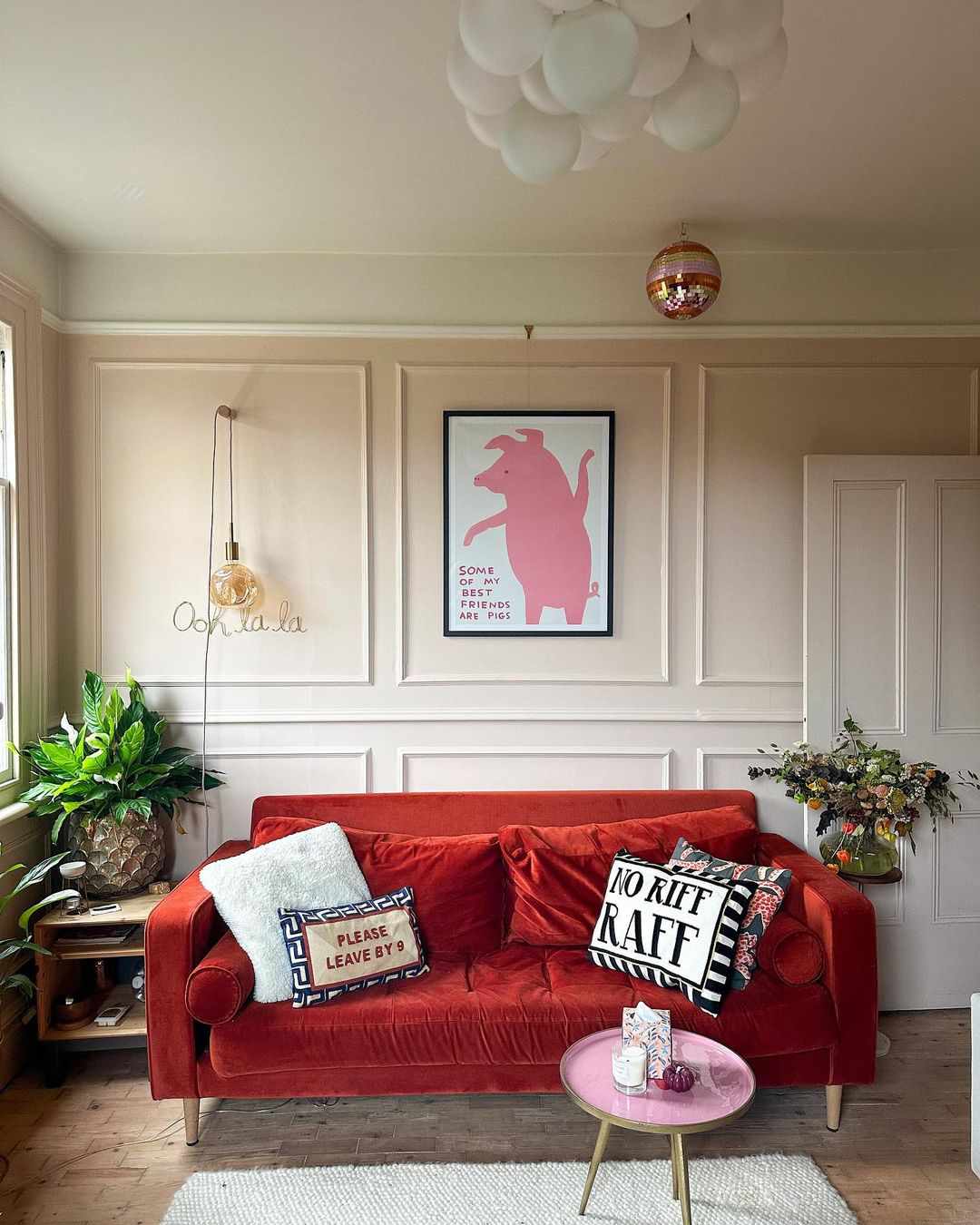 Sala de estar rosa com sofá vermelho