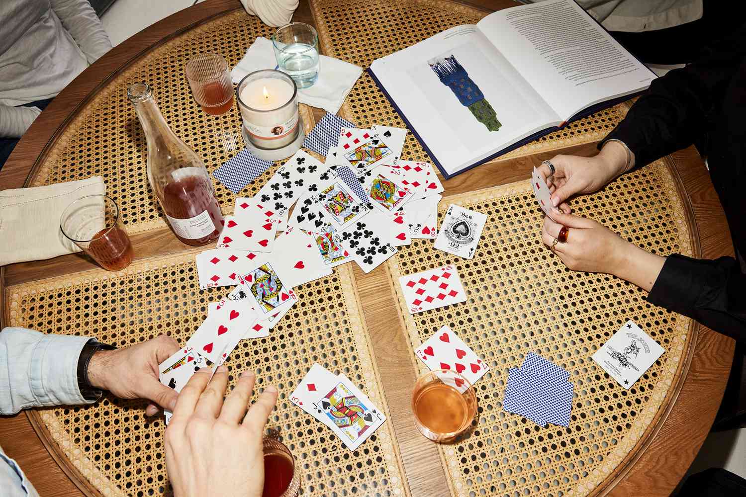 Gente jugando a las cartas en una mesa de centro de ratán