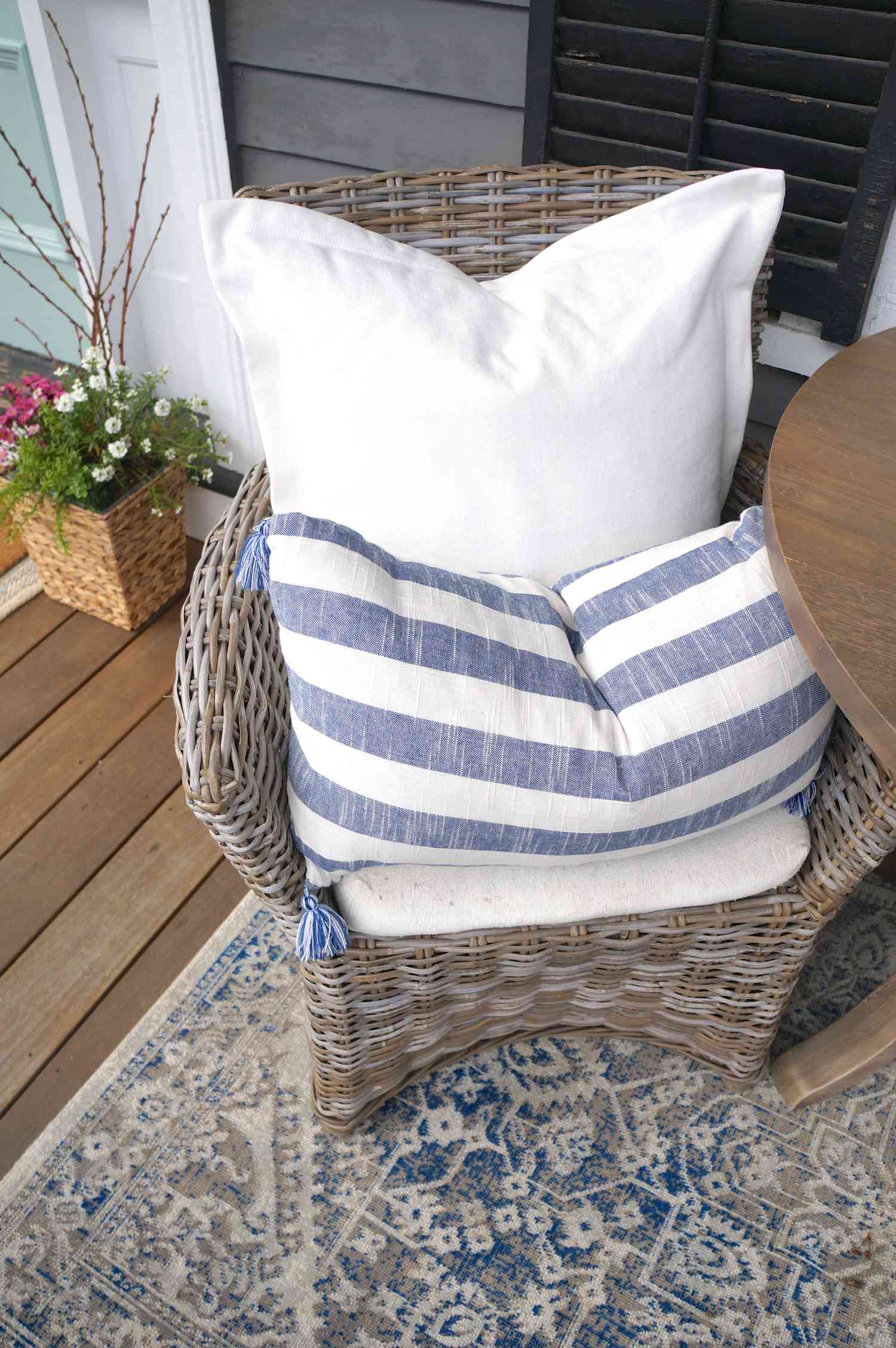 Blue and white pillows and rug on a porch