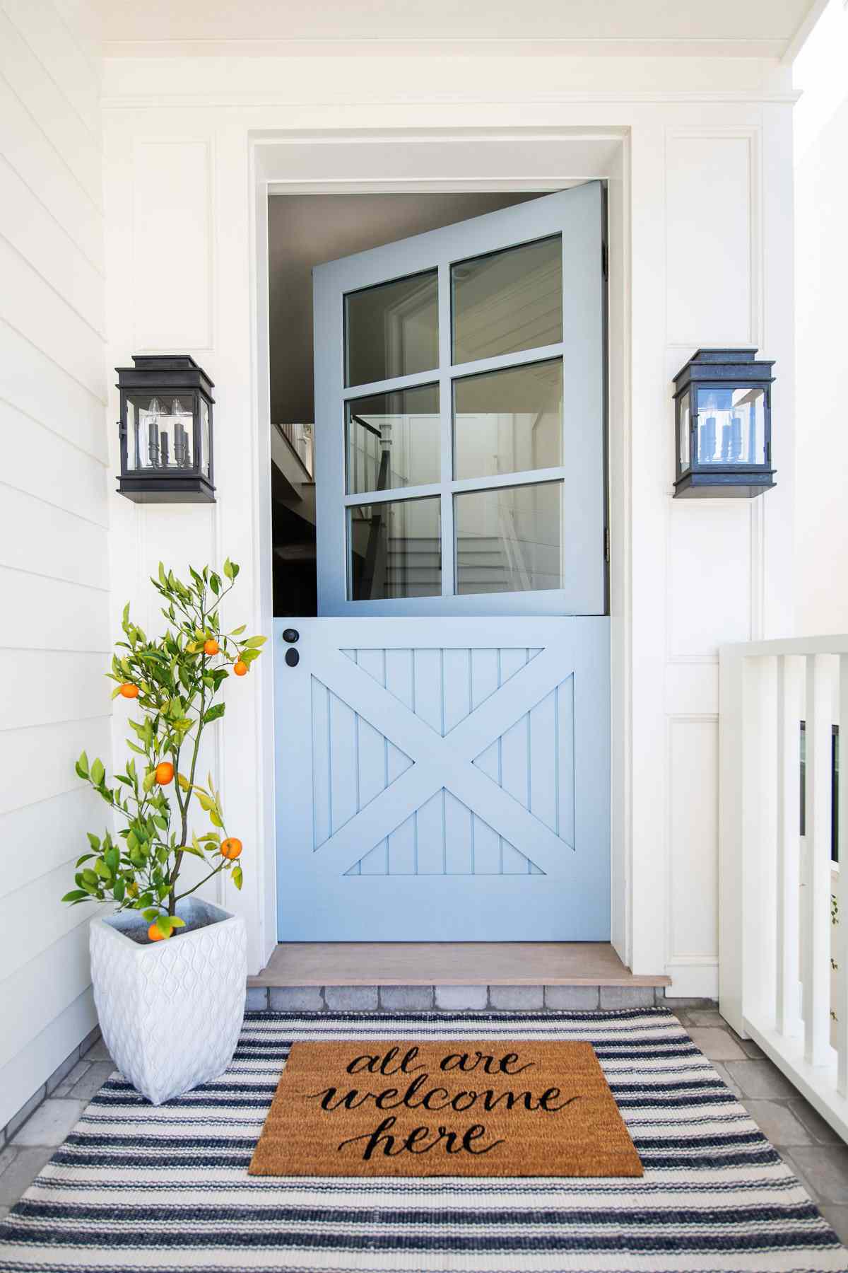 Hellblaue holländische Tür auf einer weißen Veranda