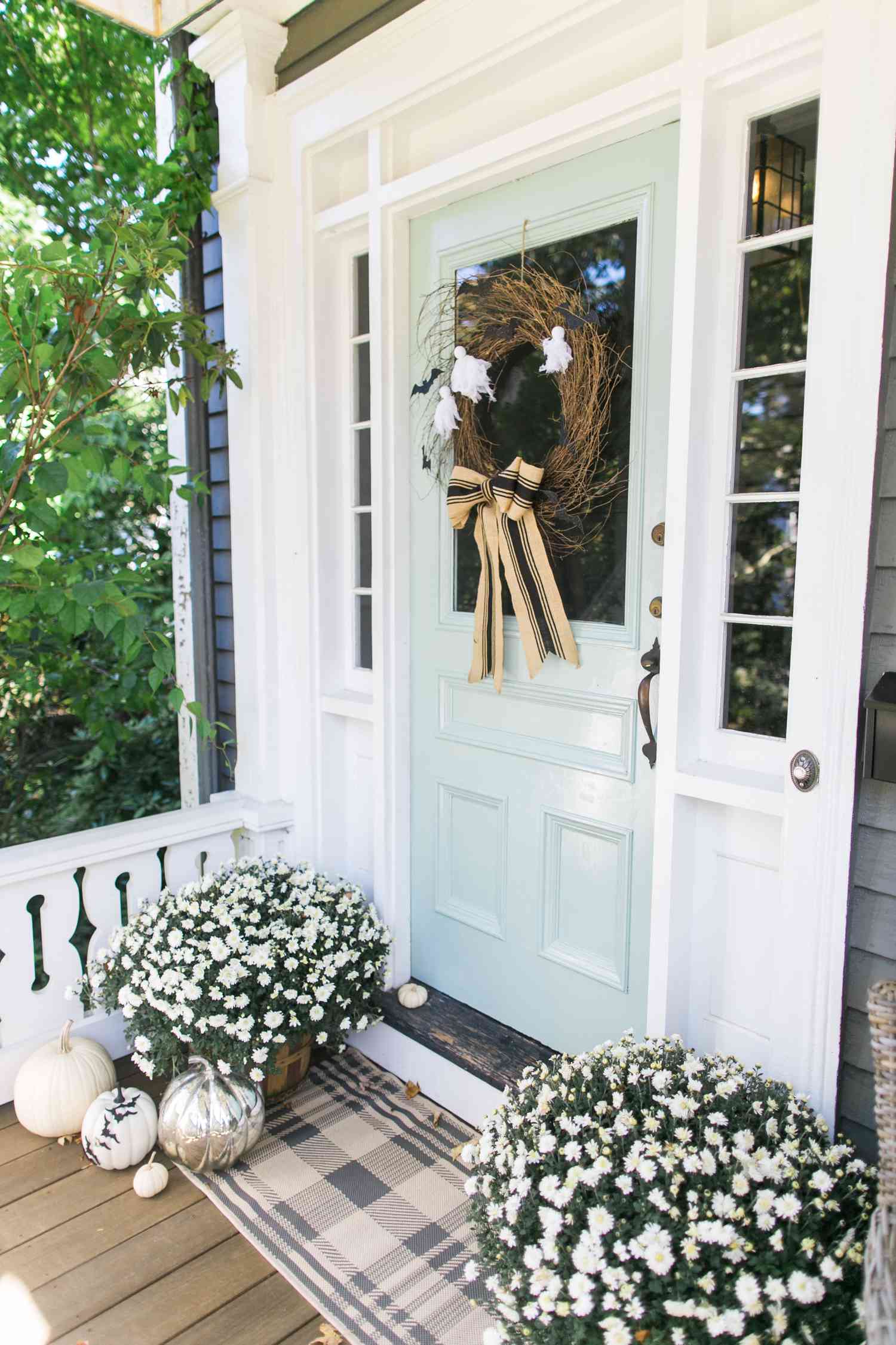 Plaid door mat in front of light blue porch door