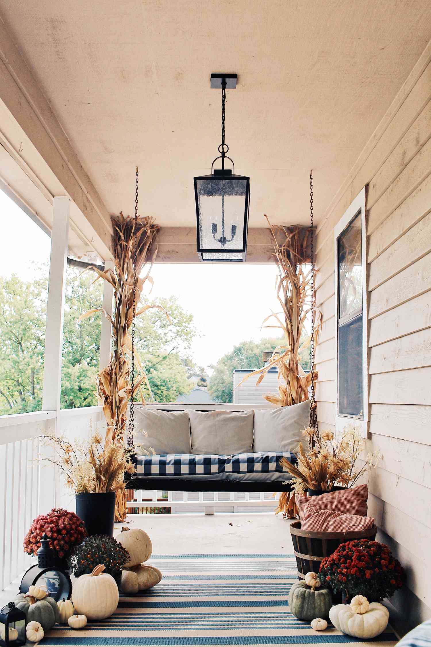 Porch swing surrounded by fall decor