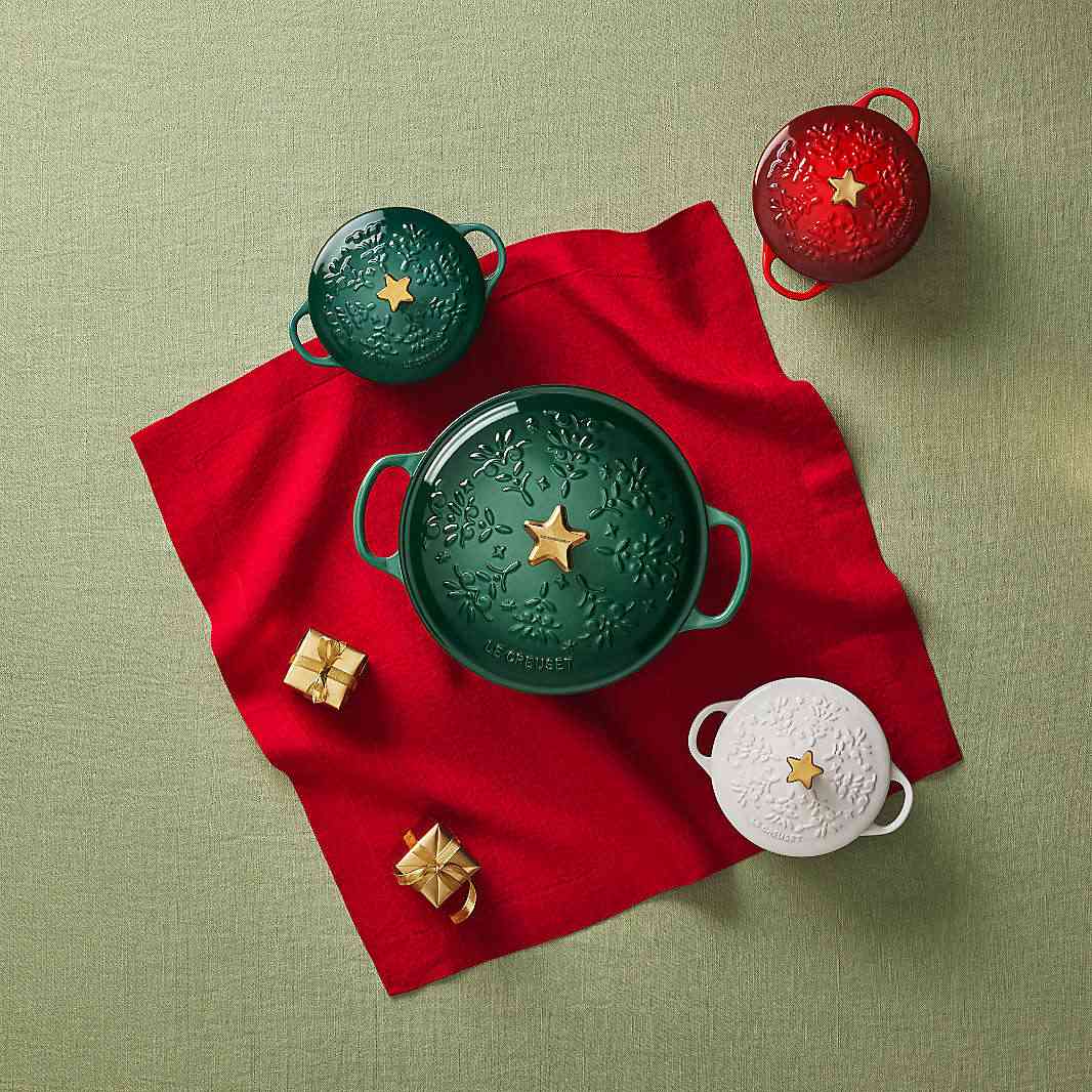 Produktbild mit vier Le Creuset Cocottes in verschiedenen Farben und Größen aus der exklusiven Weihnachtskollektion von Crate & Barrel.