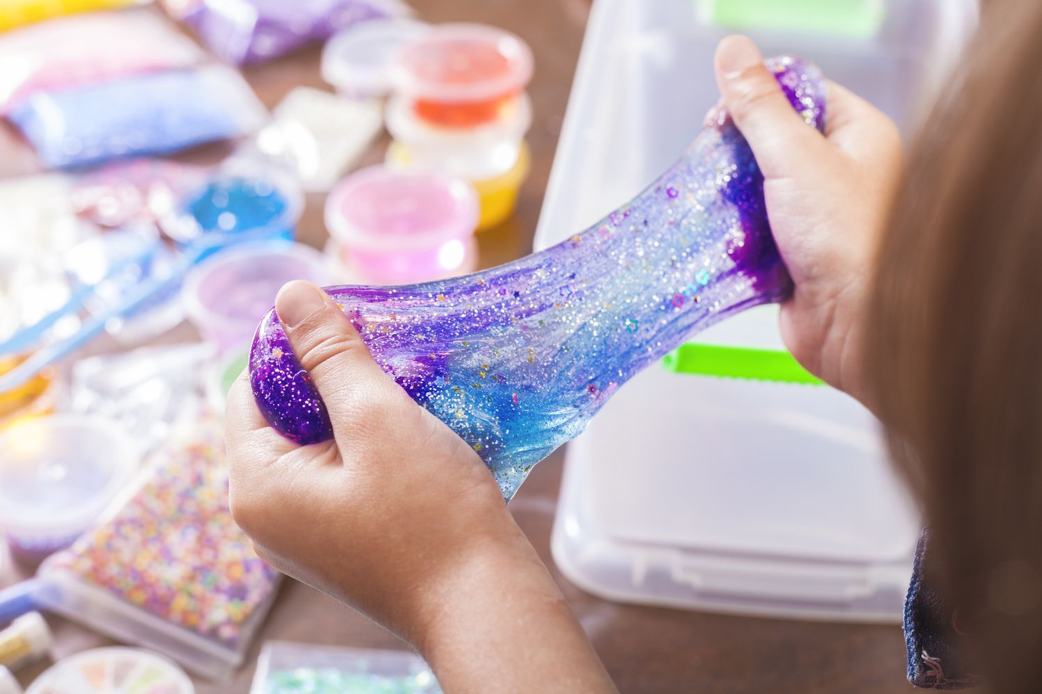 Child playing with glittery purple slime