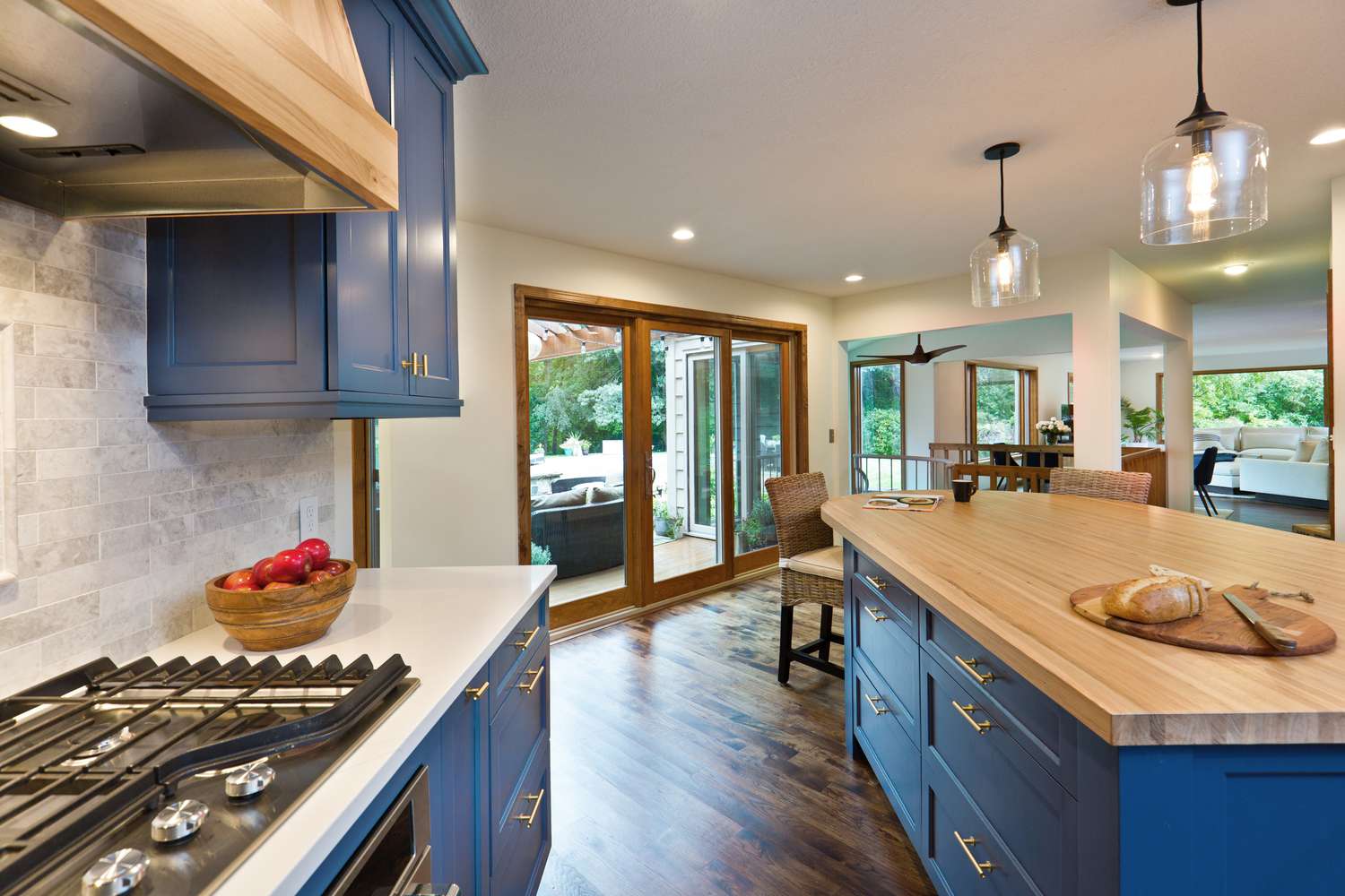 Küche mit blauen Schränken und Kücheninsel und Pendelleuchten