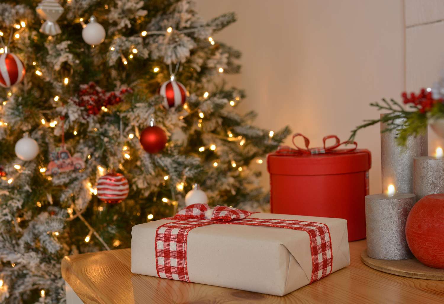 eingepacktes geschenk neben einem weihnachtsbaum