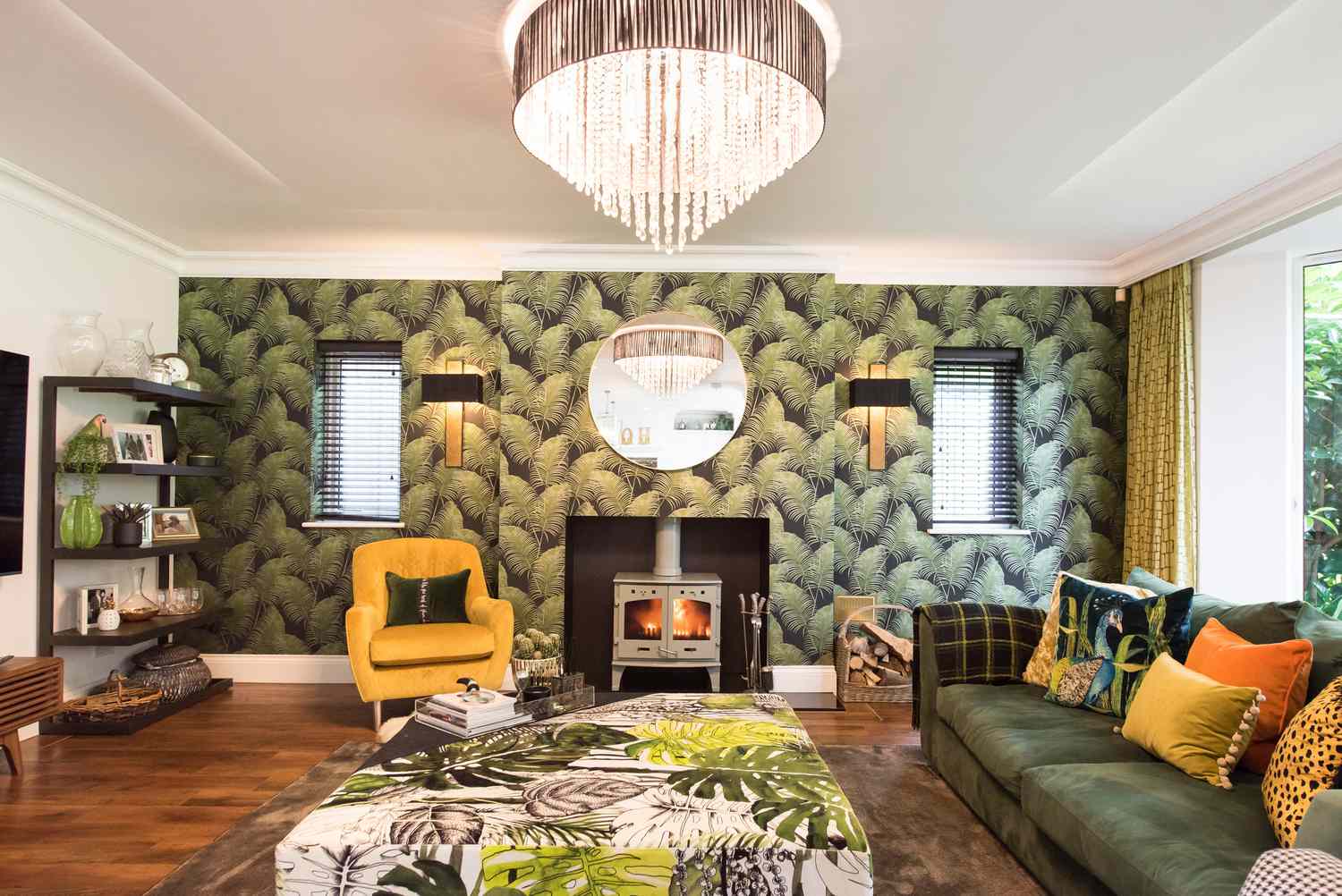 Salon avec papier peint palmier et canapé en velours vert