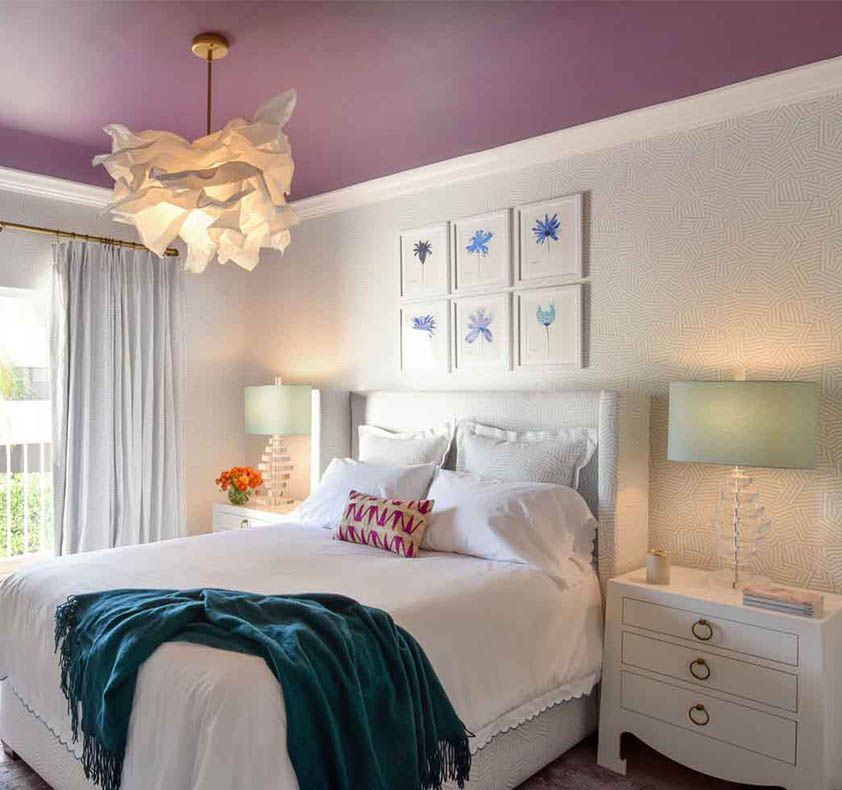 Schlafzimmer mit mintgrünen Lampenschirmen und einer lila Decke.