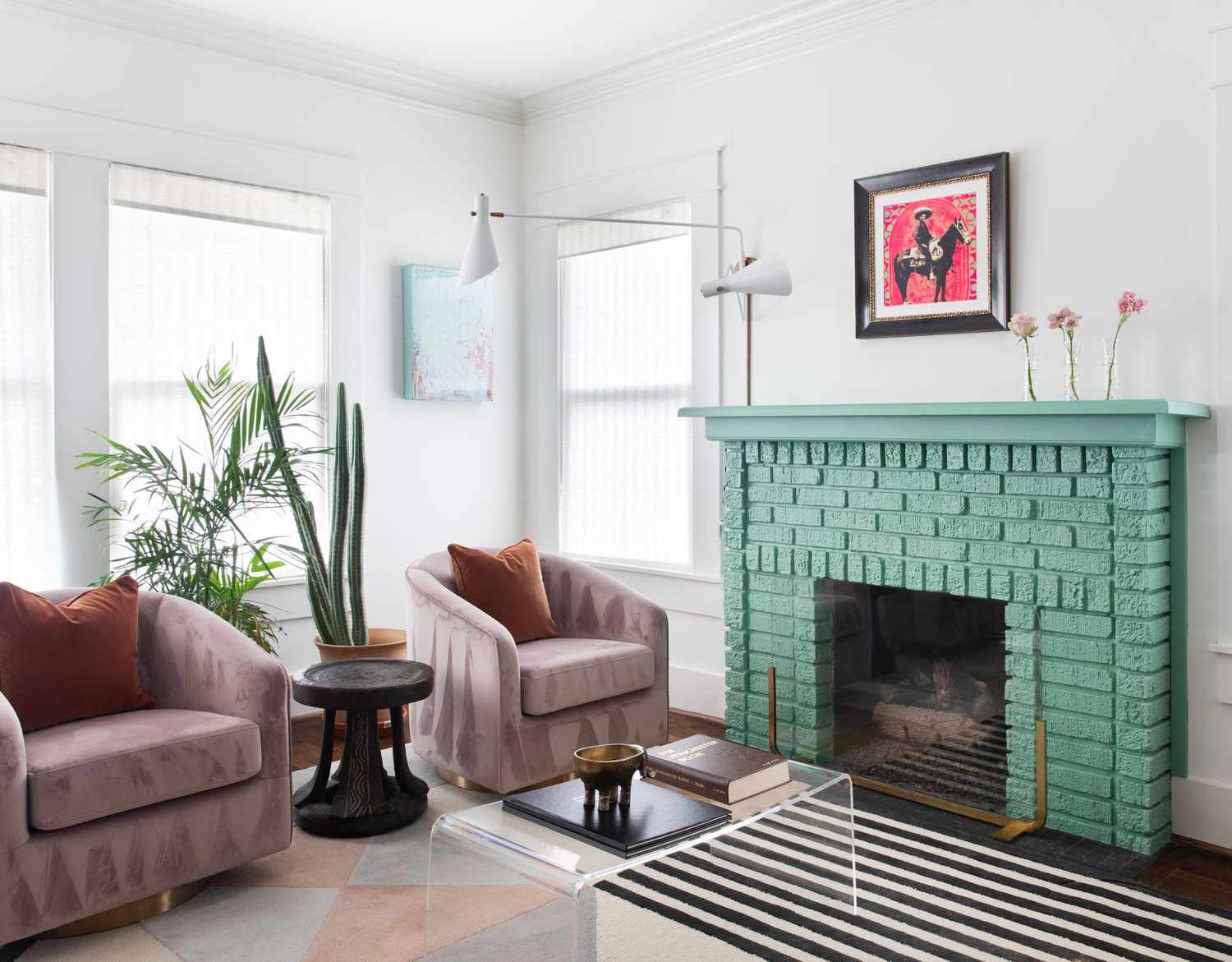 Salon avec cheminée vert menthe et chaises mauves.