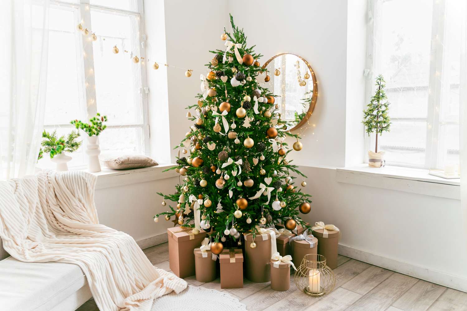 Sala de estar festiva com árvore decorada e presentes embaixo.