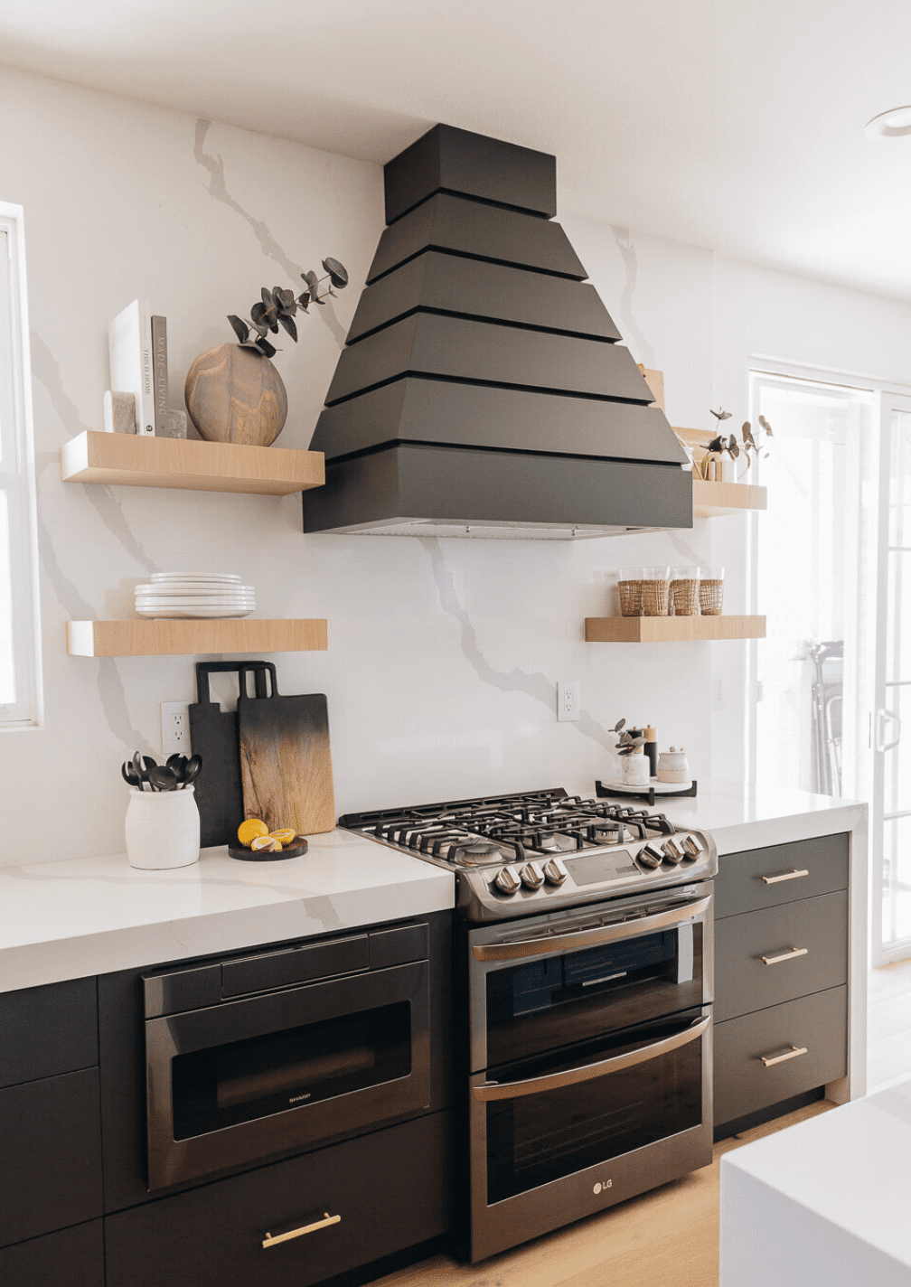 cocina en blanco, negro y dorado con campana statement