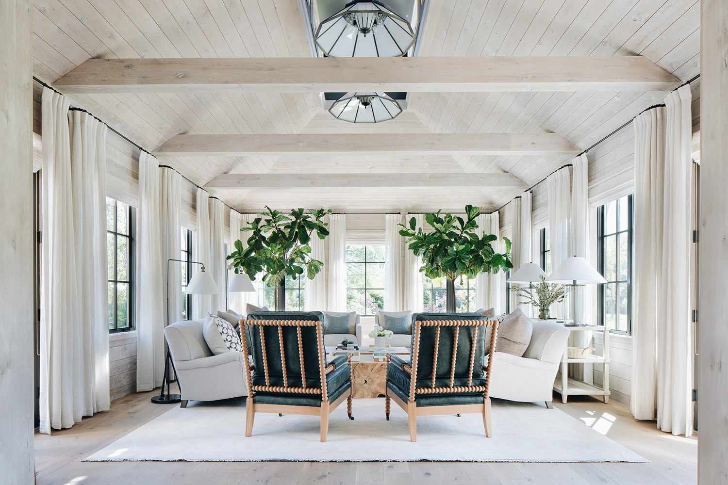 Salon avec de nombreuses fenêtres et rideaux avec murs et plafond en bois