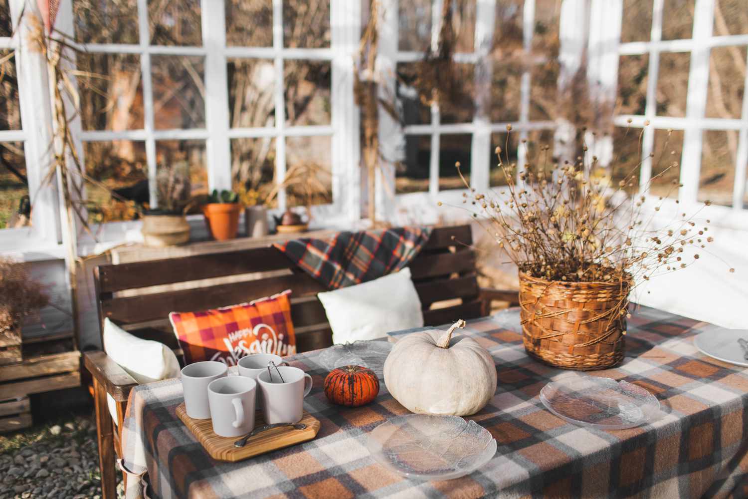 Natureza morta de outono aconchegante com abóboras, xadrez de lã tricotado, xícara de chá e abóbora. Decoração de casa de outono. Hora do chá. Clima aconchegante de outono. Ação de Graças. Atmosfera de outono.