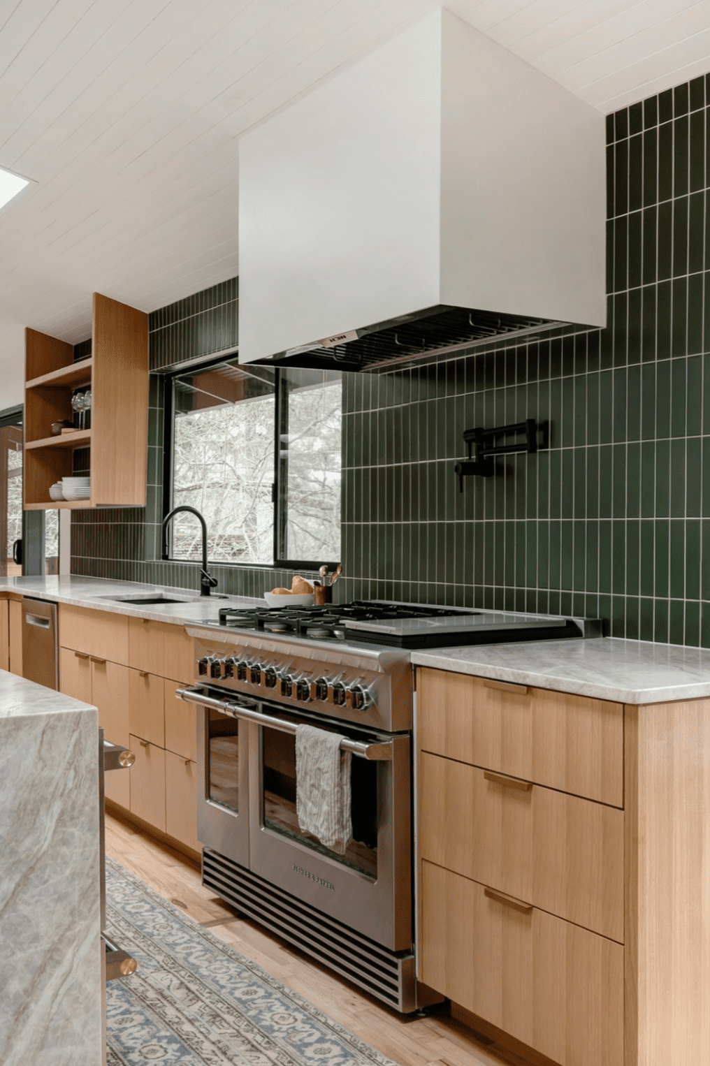 Parede de azulejos verdes em uma cozinha com armários de madeira