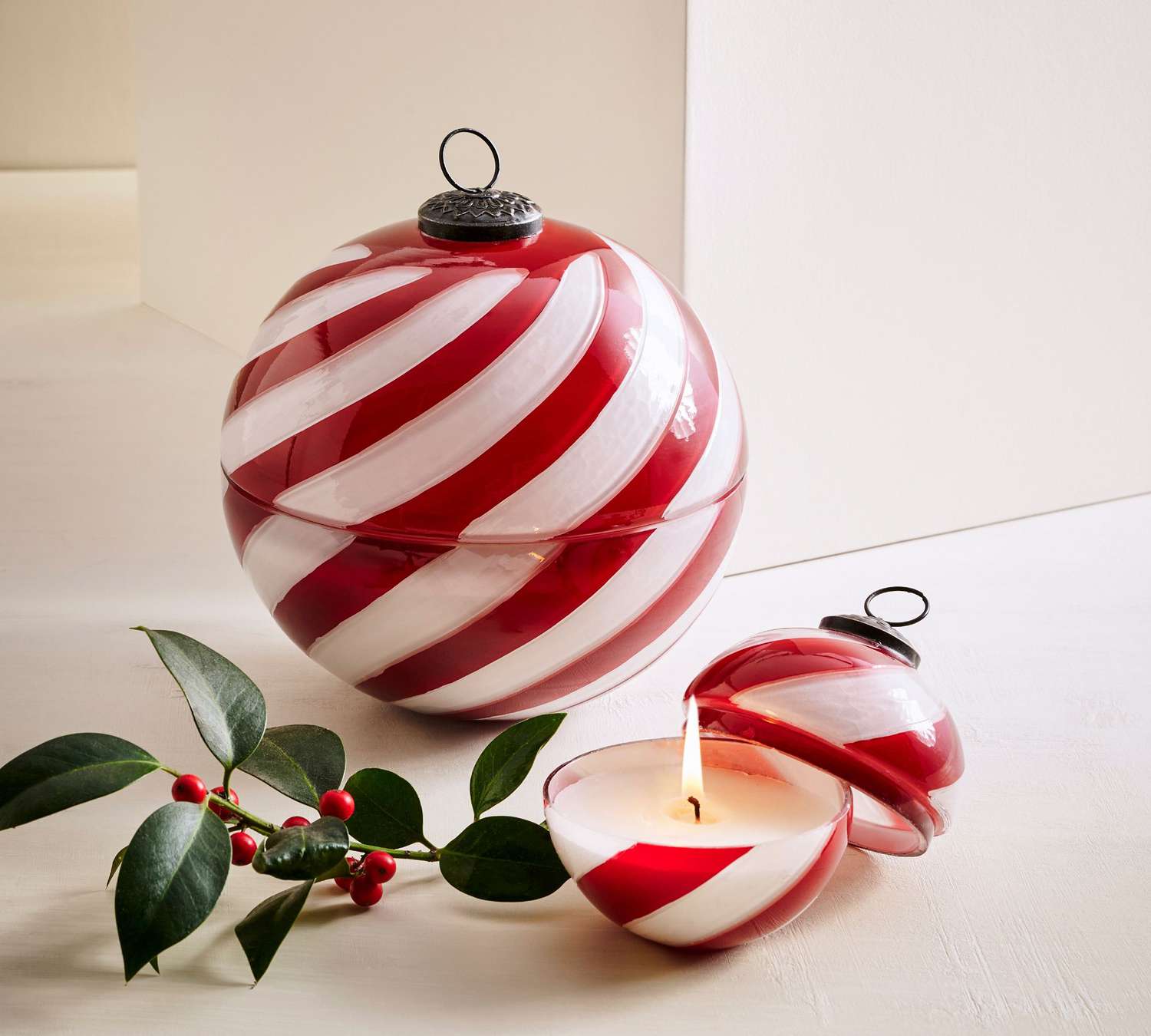 Kerze in Form eines Ornaments mit roten und weißen Wirbeln
