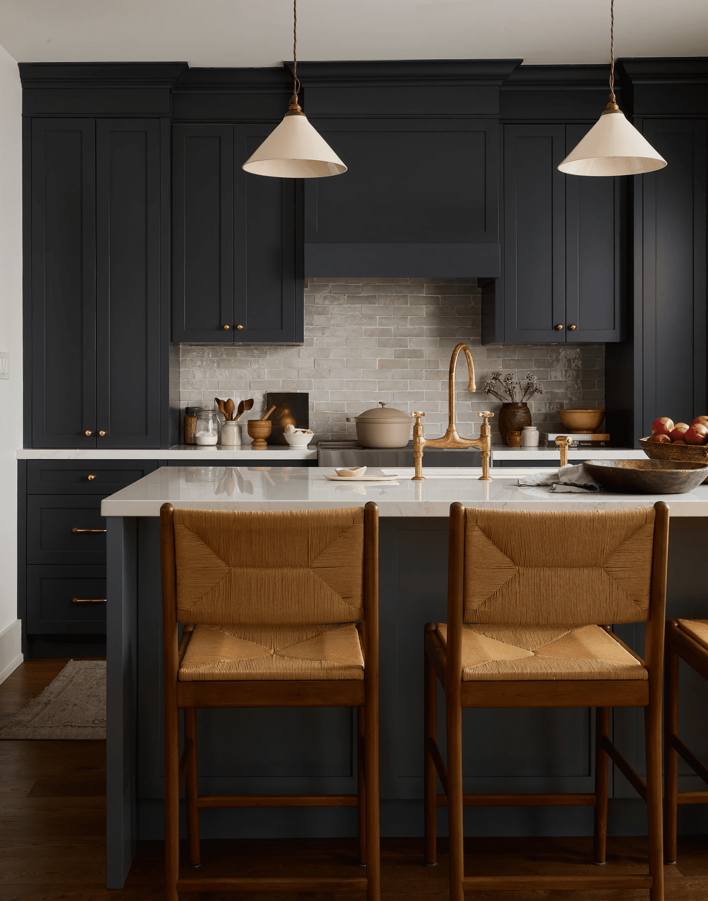 Moody blue kitchen with wood toned island chairs.