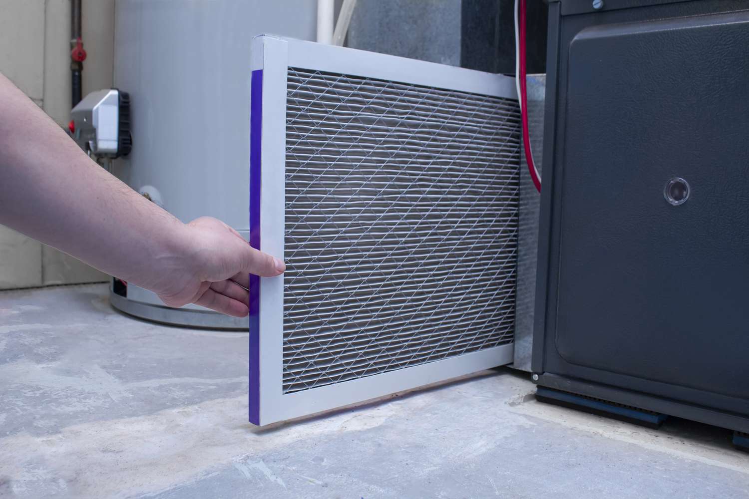 Person replacing a furnace filter