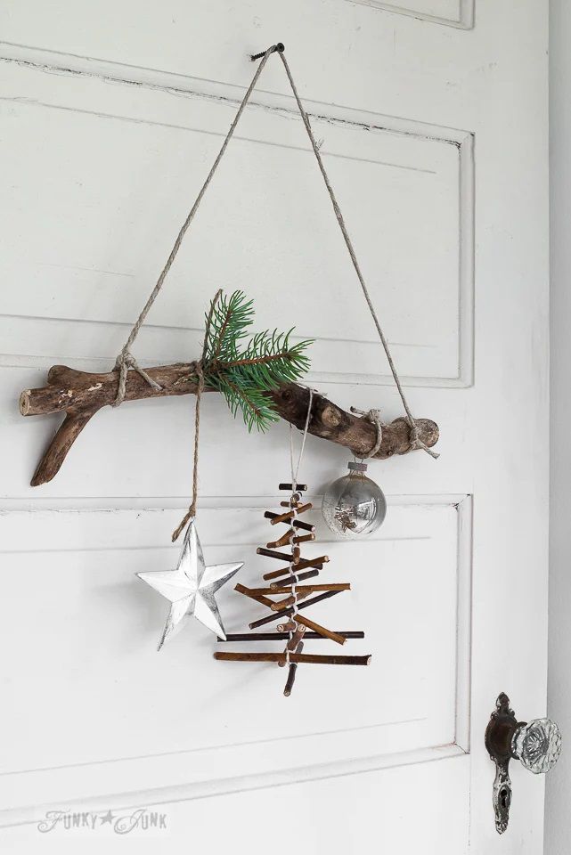Una rama de árbol colgada y decorada para Navidad