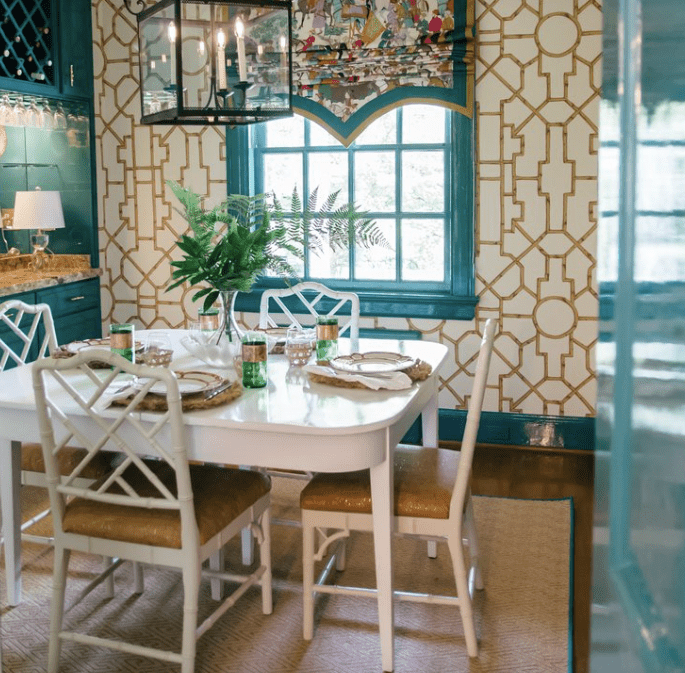 Sala de jantar maximalista com acabamento em azul-petróleo e papel de parede de bambu falso dourado e conjunto de jantar Chippendale chinês branco